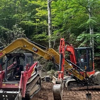 Excavator and track loader on site